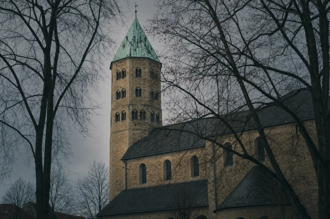 Romanischer Westturm einer westfälischen Stiftskirche aus hellem Sandstein.